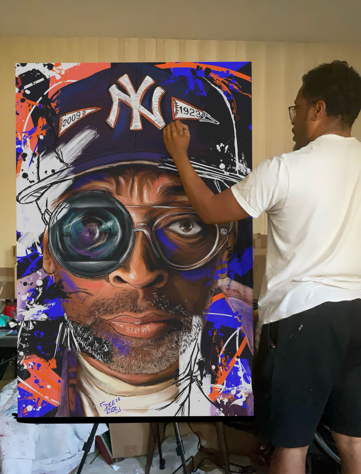 Deante Howard painting the Spike Lee canvas on an easel